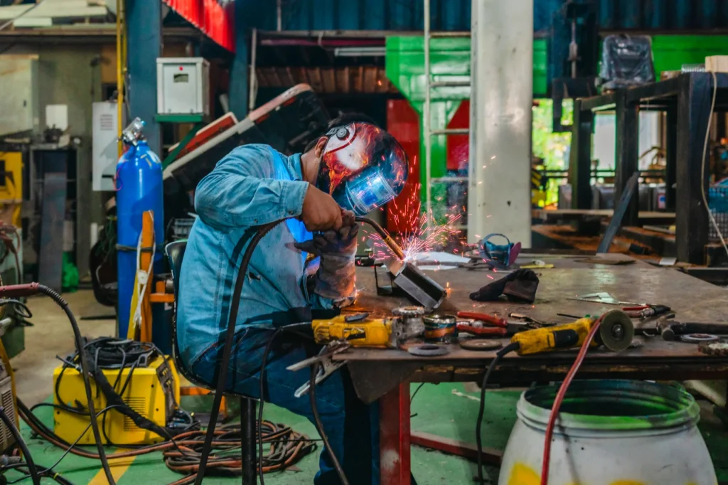 Welder performing arc welding during welder qualification testing