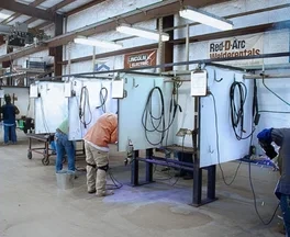 Engineers examining equipment inside the MAV-TEC welding test facility